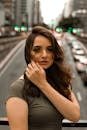 Urban portrait of a woman with flowing hair, standing in São Paulo's bustling street.