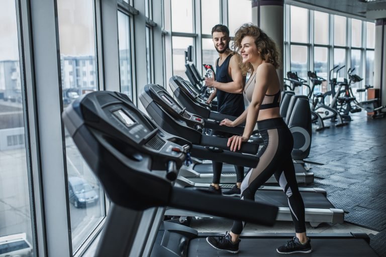 portrait of young sports couple making cardio workout in modern